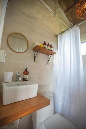 a bathroom with a sink and a mirror and a toilet at Buen Camino Hotel, San Mateo in San Mateo