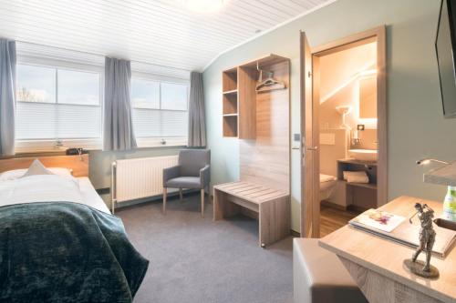 - une chambre avec un lit, un bureau et une chaise dans l'établissement Hotel zur Post - Economy Rooms, à Garrel