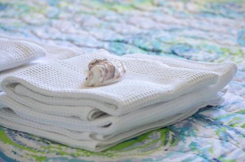 a stack of white towels on a bed at Casa Ninin in Alassio
