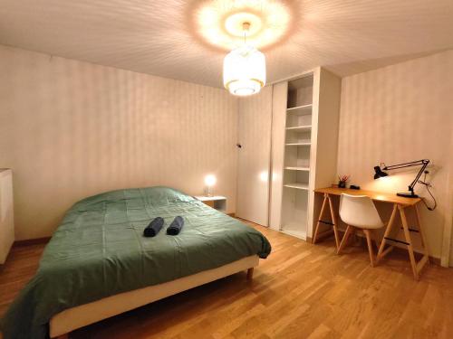 - une chambre avec un lit, une table et un bureau dans l'établissement TROIS PIECES DE CHARME AUX PORTES DE GENEVE, à Annemasse