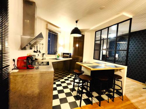 a kitchen with a black and white checkered floor at TROIS PIECES DE CHARME AUX PORTES DE GENEVE in Annemasse