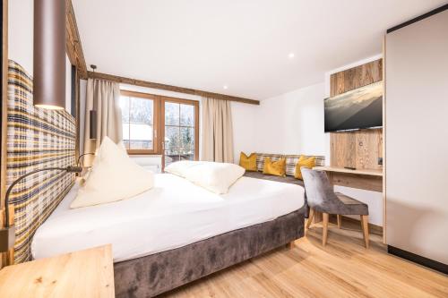 a hotel room with a bed and a tv at Appartements Schrambacherhof in Achenkirch