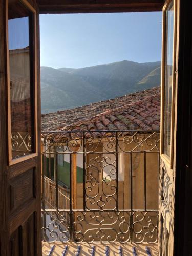 una puerta abierta a un balcón con vistas en El jazmín de la Fuente casa rural en Guijo de Santa Bárbara