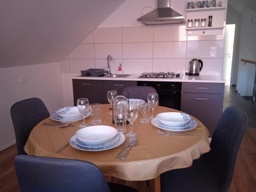 a table with plates and glasses on it in a kitchen at Seoski turizam Stari mlin na Korani apartment 1 in Karlovac