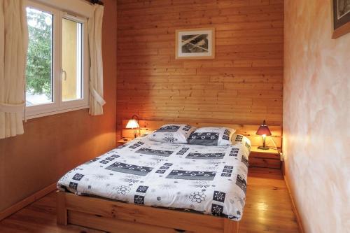 une chambre avec un lit dans une cabane en rondins dans l'établissement Gîte CARLINES - 6 personnes - 