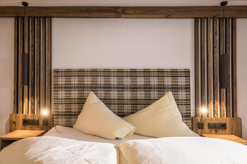 a bed with white sheets and pillows in a room at Appartements Schrambacherhof in Achenkirch