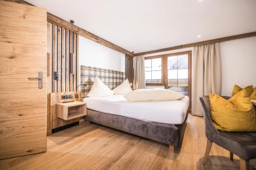 a hotel room with a bed and a chair at Appartements Schrambacherhof in Achenkirch