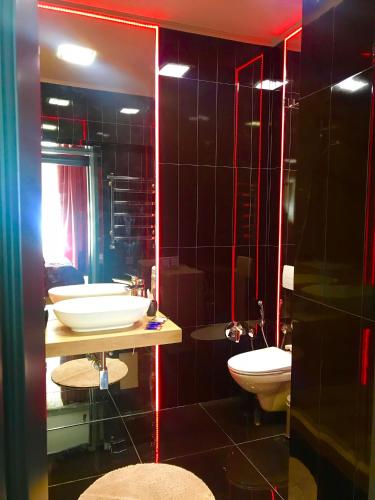 a bathroom with two sinks and a toilet and a mirror at Apartments Lux in city center Lviv in Lviv