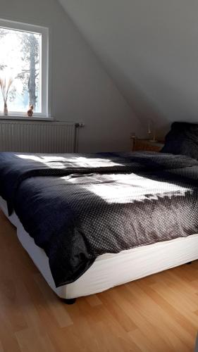 een bed in een slaapkamer met een raam bij de Grutto in Appelscha