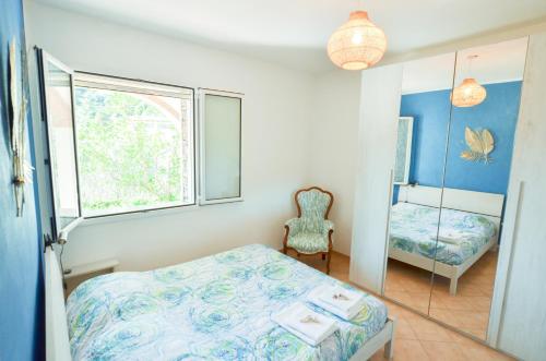 a small bedroom with a bed and a mirror at Casa Ninin in Alassio