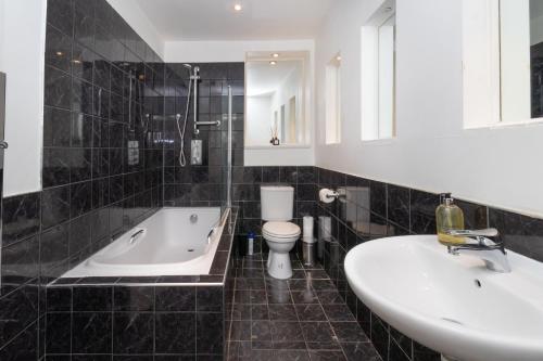 Cosy flat in leafy London في لندن: حمام مع حوض ومرحاض ومغسلة