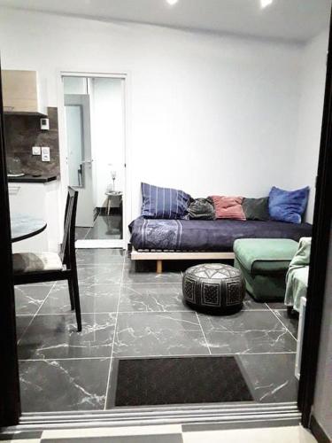 un salon avec un canapé et une table dans l'établissement Maisonnette 28 M2 au fond du jardin calme&confort, à Mondeville