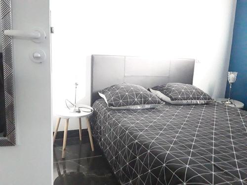 une chambre avec un lit et une table de chevet dans l'établissement Maisonnette 28 M2 au fond du jardin calme&confort, à Mondeville