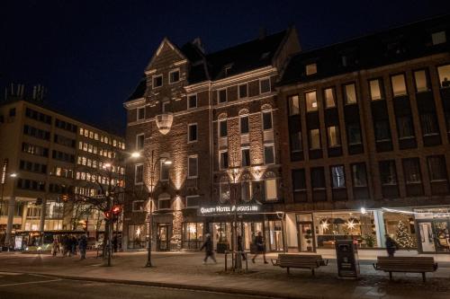 a group of buildings on a city street at night at Quality Hotel Augustin in Trondheim