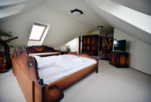 a bedroom with a large wooden bed in a attic at Camelot Club Hotel in Vác