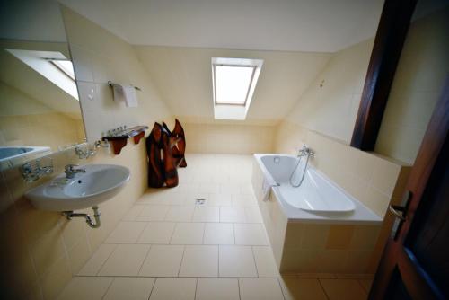 a bathroom with two sinks and a skylight at Camelot Club Hotel in Vác