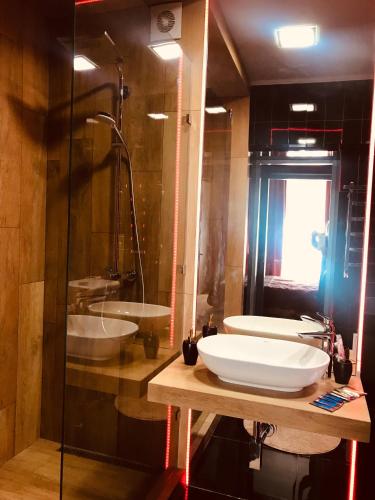a bathroom with two sinks and a glass shower at Apartments Lux in city center Lviv in Lviv