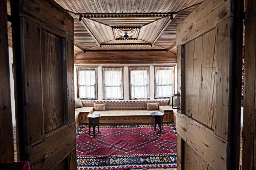 a room with a bench in a room with windows at Bosnian National Monument Muslibegovic House in Mostar