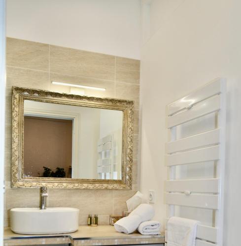 une salle de bain avec un lavabo et un miroir dans l'établissement Premium Apartment, à Nice