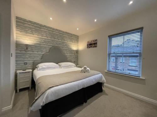 um quarto com uma cama grande e uma parede de tijolos em Isabel Cottage em Keswick