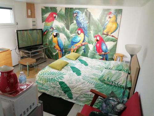 - une chambre avec une fresque murale représentant des perroquets dans l'établissement Studio Les oiseaux, à Saint-Georges-sur-Baulche