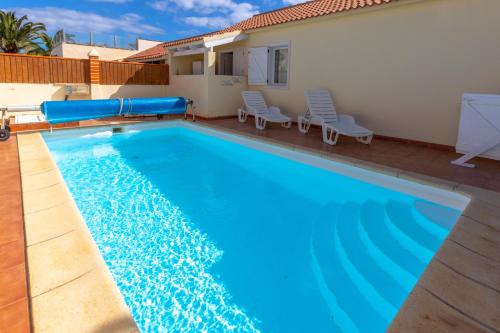 una piscina de agua azul en una villa en Private villa with heated pool & terrace see view, en Corralejo