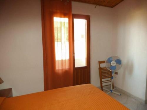 um quarto com uma cama, uma janela e uma ventoinha em Mansarda M&M SX em Castellammare del Golfo