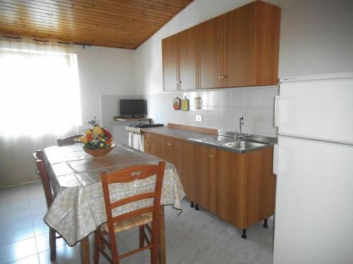 uma cozinha com uma mesa e um frigorífico branco em Mansarda M&M SX em Castellammare del Golfo