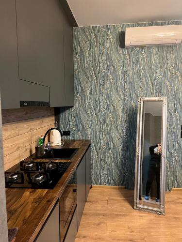 a person taking a picture of a mirror in a kitchen at Apartments Lux in city center Lviv in Lviv