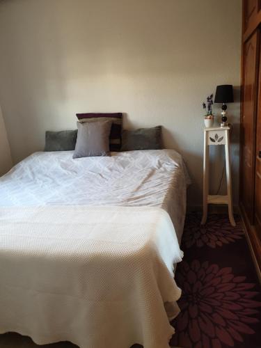ein Schlafzimmer mit einem weißen Bett und einem kleinen Tisch in der Unterkunft Casa de la musica in Camposol