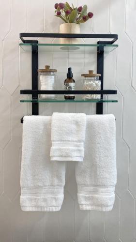 a towel rack with three white towels on it at Hidden Oasis in Deerfield Beach with Heated Pool in Deerfield Beach
