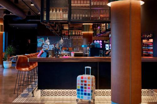 a bar with a suitcase sitting in front of it at MOXY Denver Cherry Creek in Denver