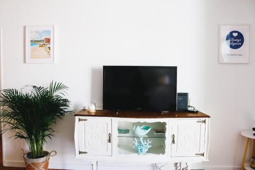 a tv on top of a cabinet in a living room at Amélia - Always Algarve in Armação de Pêra