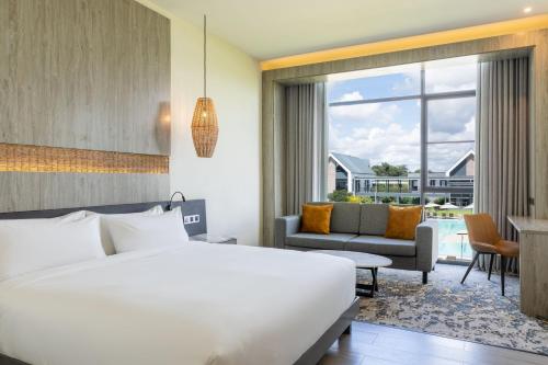 Ciêla, Lusaka, a Tribute Portfolio Resort and Spa في لوساكا: غرفة نوم بسرير كبير وغرفة معيشة