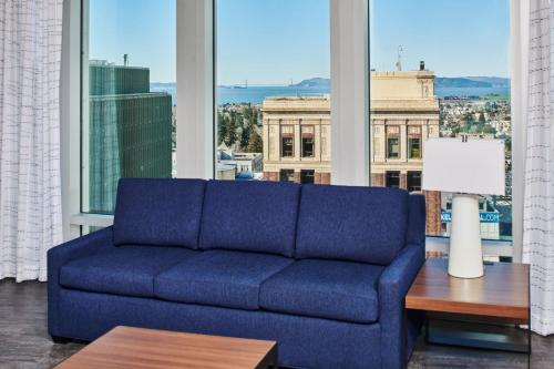 a blue couch in a room with a large window at Residence Inn By Marriott Berkeley in Berkeley
