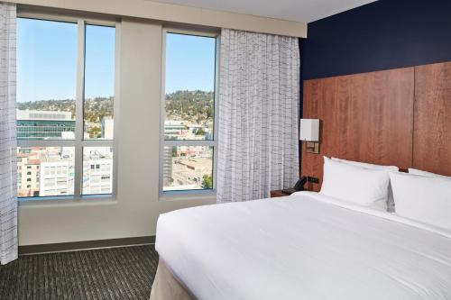 a bedroom with a large white bed and large windows at Residence Inn By Marriott Berkeley in Berkeley