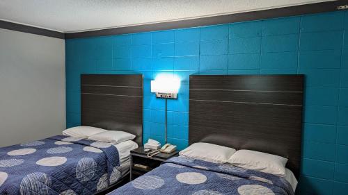 two beds in a room with blue walls at Sheridan Inn in Sheridan