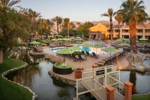 un complejo con una piscina con mesas y sombrillas en The Westin Rancho Mirage Golf Resort & Spa en Rancho Mirage