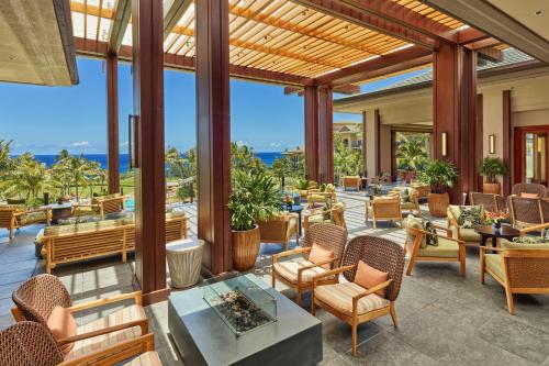 an outdoor patio with chairs and tables and a view of the ocean at The Ritz-Carlton Maui, Kapalua in Lahaina