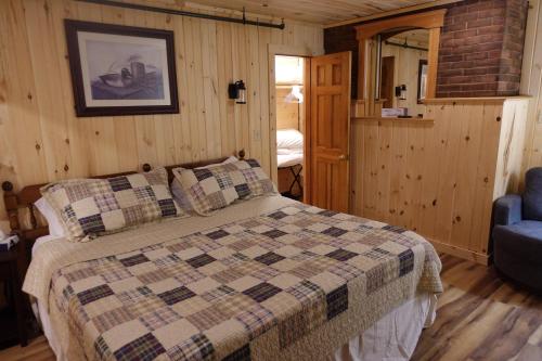 a bedroom with a bed in a room with wooden walls at Rangeley Saddleback Inn in Rangeley