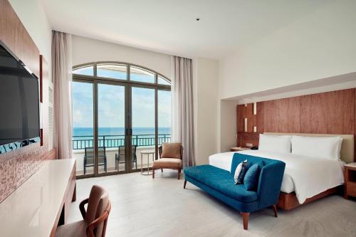 カンクンにあるJW マリオット カンクン リゾート ＆ スパのベッドと大きな窓が備わるホテルルームです。