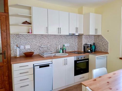 a kitchen with white cabinets and a sink at Lovely forest escape, Mountain Lake complex in Smolyan