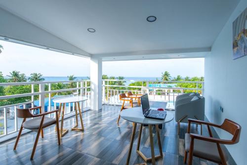 a room with a balcony with a laptop on a table at FUNPLACE BEACH in Himmafushi