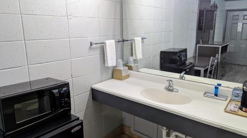 a bathroom with a sink and a microwave at Sheridan Inn in Sheridan