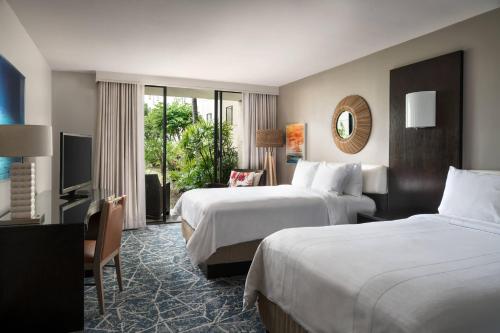 a hotel room with two beds and a television at Waikoloa Beach Marriott Resort & Spa in Waikoloa