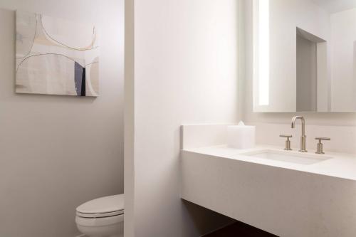 a bathroom with a toilet and a sink and a mirror at Waikoloa Beach Marriott Resort & Spa in Waikoloa