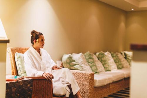a woman sitting in a chair with a cup of coffee at Waikoloa Beach Marriott Resort & Spa in Waikoloa