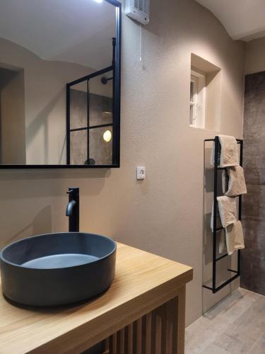 a bathroom with a black sink and a mirror at Det Blå Gæstehus in Fanø