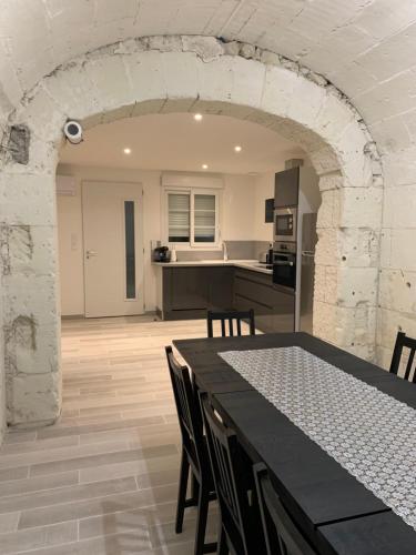 une cuisine et une salle à manger avec une table et des chaises dans l'établissement la cavonnière, à Saint-Aignan
