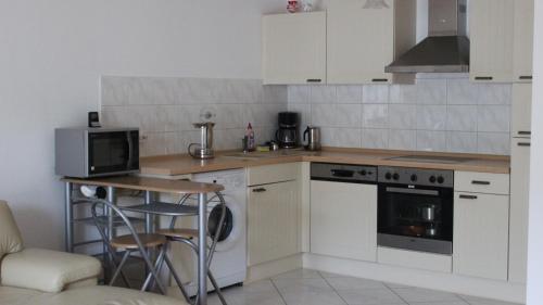 a kitchen with white cabinets and a table and a microwave at Sonnenschein in Baden-Baden